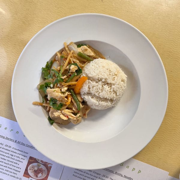 A white bowl of Sern Sapp Restaurant's Laos cuisine, featuring stir-fried chicken and vegetables with a side of rice.